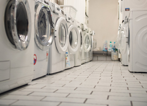 Laundry room of an apartment house in the basement with some washers in a row stock photo