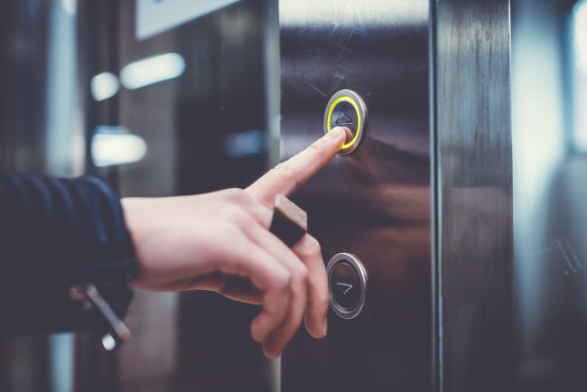 Hand pushing elevator buttons.