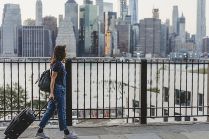 Young woman travelling in New York with suitcase